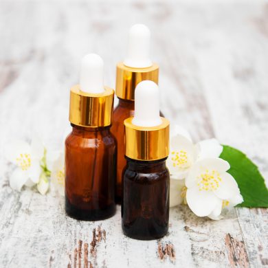 Massage oils and jasmine flowers on a wooden table